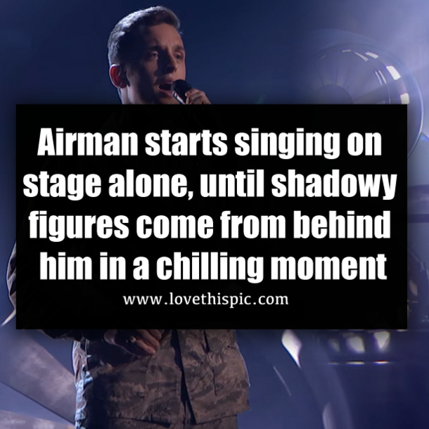 Airman starts singing on stage alone, until shadowy figures come from behind him in a chilling moment