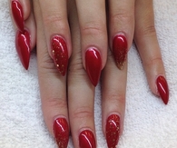 Red stiletto nails with gold glitter